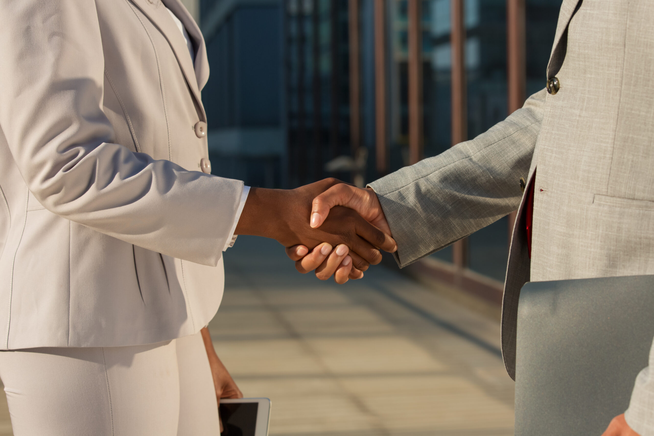 african american businesswoman shaking hands with male partner